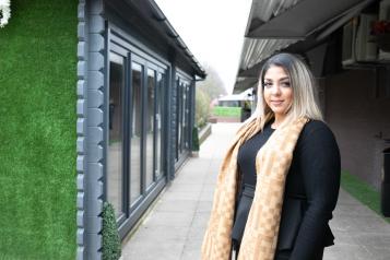 Woman stood outside in a courtyard wearing a bright scarf